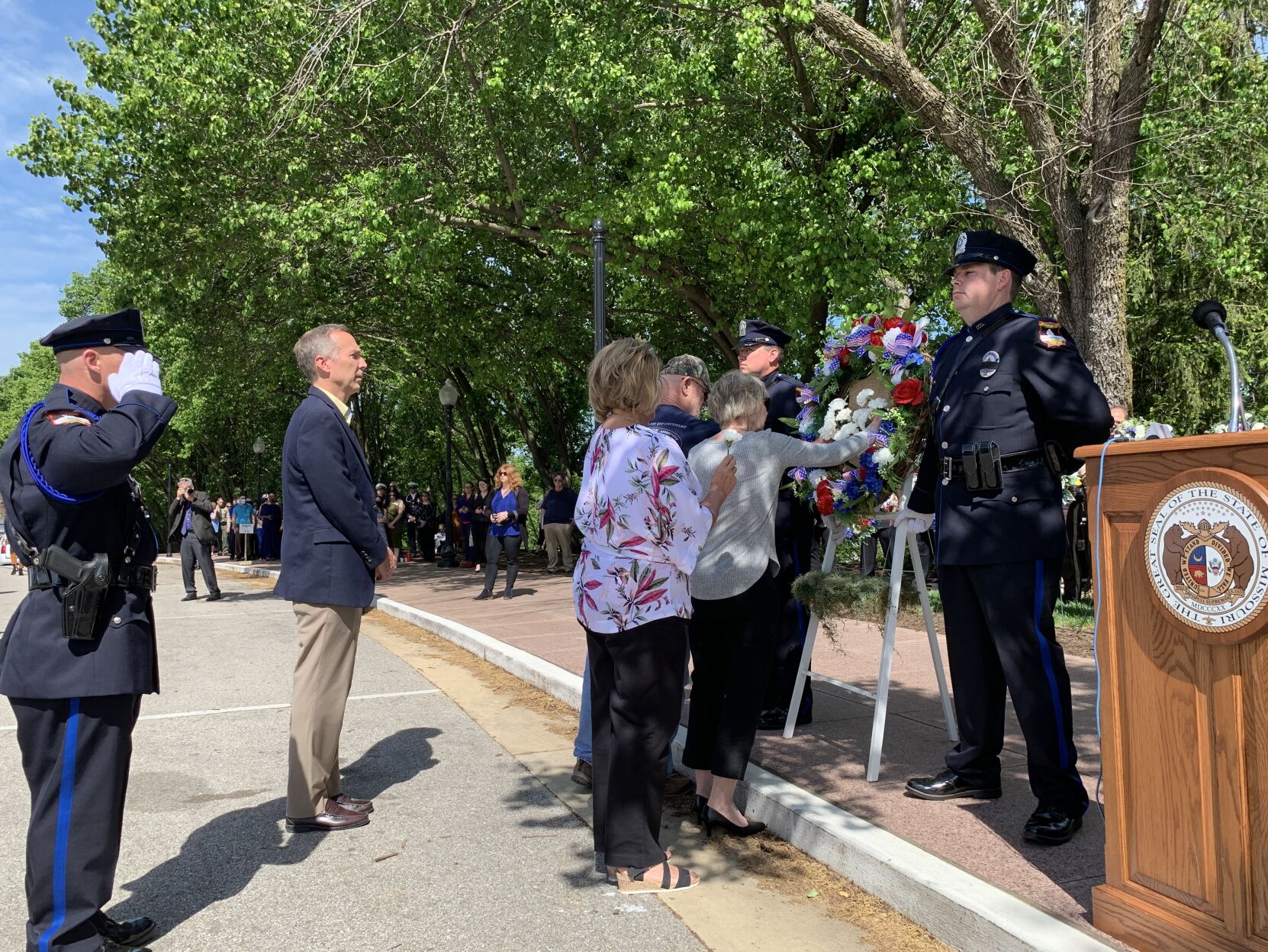 Families of fallen officers lay white rose on wreath